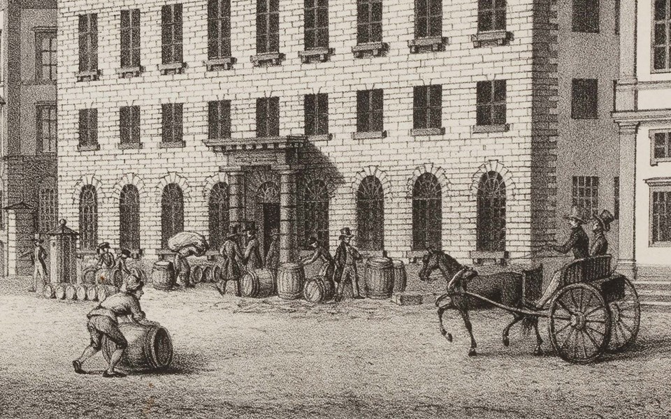 Framför Tullhuset står tunnor uppradade och människor rör sig utanför. En man rullar en tunna, en tvåhjulig vagn dragen av en häst passerar till höger i bild.